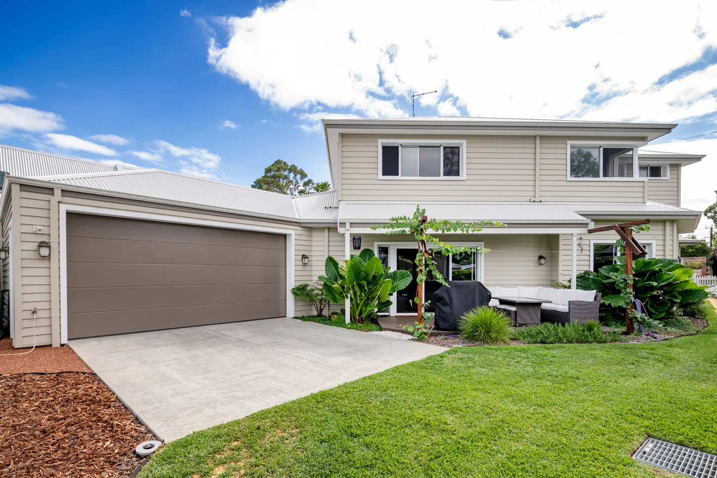 Street frontage of the Katherine and Brett Bayswater home, a two-storey weatherboard house with a double garage, grapevine pergola and landscaped front lawn